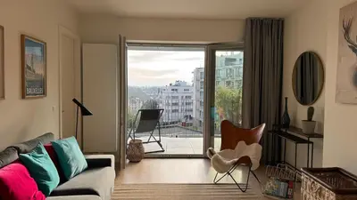 a living room with a couch and chairs and a window at Chez Pomme in Brussels