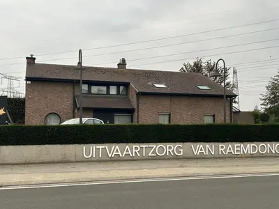 a brick house with a sign in front of it at Steves Place Haasdonk in Beveren
