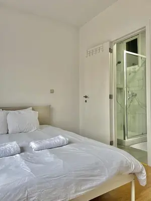 a white bed with two pillows on top of it at Spacious Apartment for 6 near Center of Brussels in Brussels