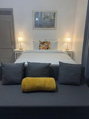 a bedroom with a large bed with a yellow pillow at La Perla Appartements Louise RDC in Brussels