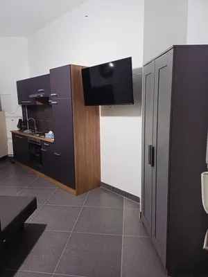 a room with a kitchen with a tv on the wall at La Perla Appartements Louise RDC in Brussels