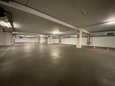 an empty parking garage with orange cones in it at La Perla Appartements Louise RDC in Brussels