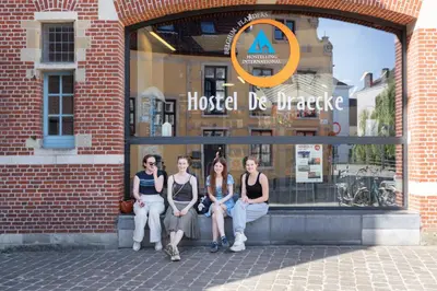 a group of women sitting in front of a building at De Draecke Hostel in Ghent