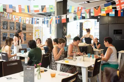 a group of people sitting at tables in a restaurant at De Draecke Hostel in Ghent