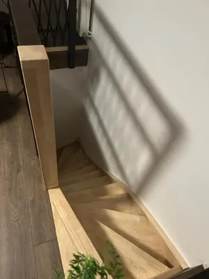 a staircase with a wooden floor and a window at Steves place Temse in Sint-Niklaas