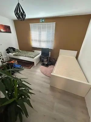 a bedroom with two beds and a window at Steves place Temse in Sint-Niklaas