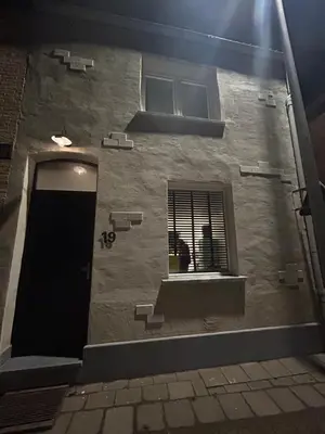a building with a window with a person looking out of it at Steves place Temse in Sint-Niklaas