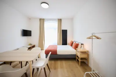 a bedroom with a bed and a table and chairs at Appartement Ceuppens 5 in Brussels