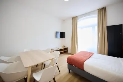 a hotel room with a bed and a table and chairs at Appartement Ceuppens 5 in Brussels