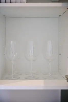 four wine glasses sitting on a white shelf at Appartement Ceuppens 5 in Brussels