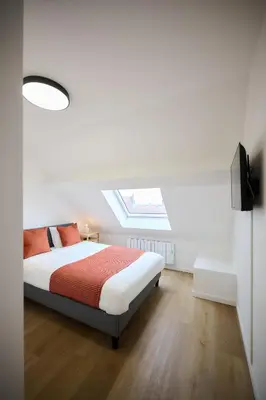 a white bedroom with a bed and a skylight at Appartement Ceuppens 5 in Brussels