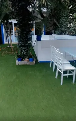 two white chairs and a tree in a yard at Majorelle in Brussels