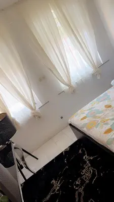 a bedroom with a bed and a window with curtains at Majorelle in Brussels