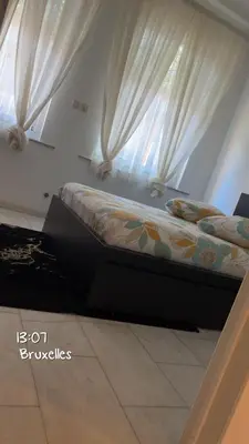 a bed in a room with a window with curtains at Majorelle in Brussels