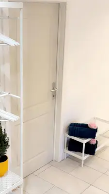 a white door in a white room with a bench at Majorelle in Brussels