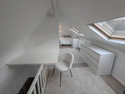 a white room with a desk and a chair at upper st in Brussels