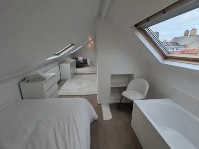 a white room with a bed and a window at upper st in Brussels