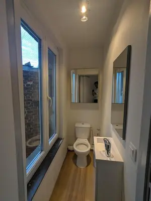 a bathroom with a toilet and a sink and a window at upper st in Brussels