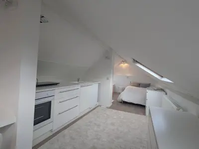 a kitchen with white cabinets and a bed in a room at upper st in Brussels