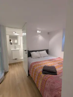 a bedroom with a bed and a room with a mirror at cozy nest basement st gilles in Brussels