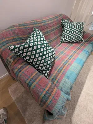a bed with three pillows on top of it at cozy nest basement st gilles in Brussels