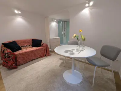 a living room with a table and a couch at cozy nest basement st gilles in Brussels