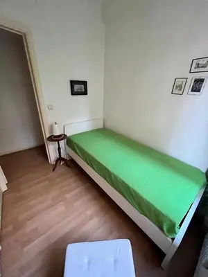 a small bedroom with a green bed in a room at Bright and cosy apartment in Bruxelles in Brussels