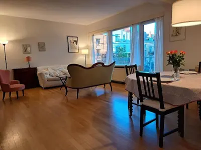 a living room with a table and chairs and a couch at Bright and cosy apartment in Bruxelles in Brussels
