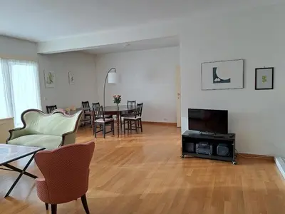 a living room with a television and a table and chairs at Bright and cosy apartment in Bruxelles in Brussels