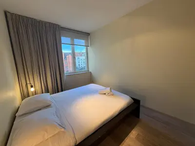 a small bedroom with a bed and a window at Apartment with 2 Bedrooms - Sleeps 6 in Brussels
