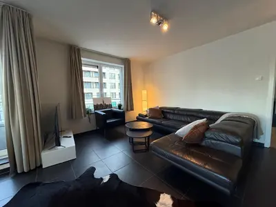 a living room with a leather couch and a television at Stunning Apartment with 2 Bedrooms - Sleeps 6 in Brussels