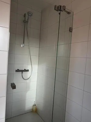 a shower with a glass door in a bathroom at L'Excelsior Suites in Brasschaat