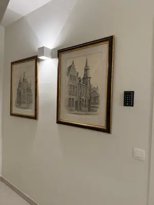 three framed pictures hanging on a white wall at L'Excelsior Suites in Brasschaat