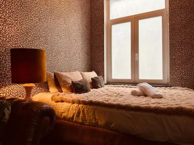 a bedroom with a large bed with a window at Sablon Muse Apartment in Brussels