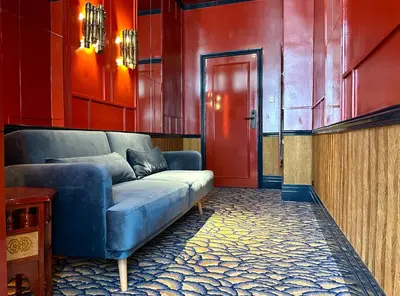 a living room with a blue couch and a red door at Sablon Muse Apartment in Brussels