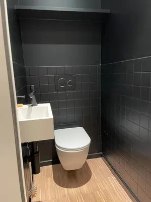 a bathroom with a white toilet and a sink at Luxury apartment with a view of the MAS in Antwerp