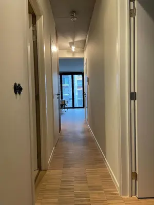 a hallway with white walls and a wooden floor at Luxury apartment with a view of the MAS in Antwerp