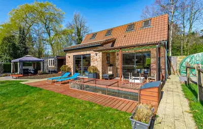 a house with a deck with blue chairs on it at Beautiful Home In Arendonk With Sauna in Arendonk