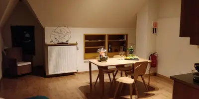 a kitchen with a table and chairs in a room at Klik Klak Studio in Bornem