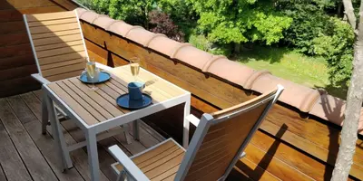a wooden table and two chairs on a deck at Klik Klak Studio in Bornem