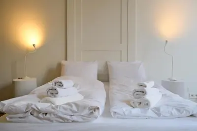 a bedroom with two towels on the bed at Maison Gustave in Ghent
