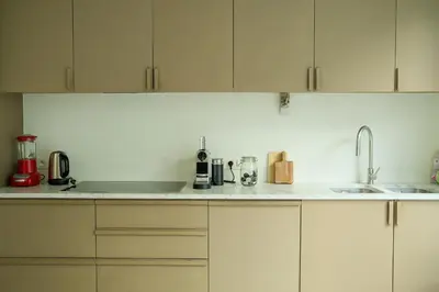 a kitchen with white cabinets and a counter top at Maison Gustave in Ghent