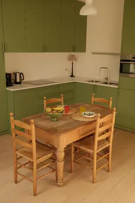 a wooden table with two chairs and a bowl of fruit at Maison Gustave in Ghent