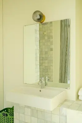 a bathroom with a white sink and a mirror at Maison Gustave in Ghent