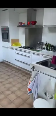 a kitchen with white cabinets and a sink and a counter at Tomorrowland in Rumst