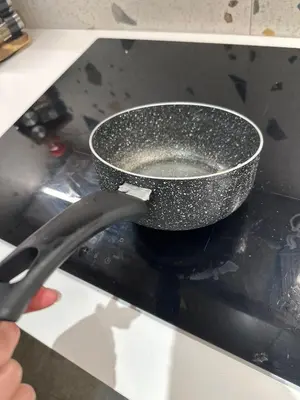 a person holding a black bowl on a stove at Tomorrowland 350 m Close Quiet Stay in Boom