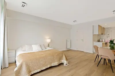 a white bedroom with a bed and a table with chairs at Apartment in the center of Antwerp in Antwerp