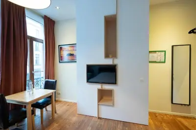 a dining room with a table and a television on a wall at tam tam city lodge in Antwerp