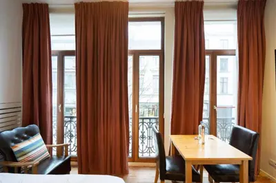 a dining room with a table and chairs and windows at tam tam city lodge in Antwerp