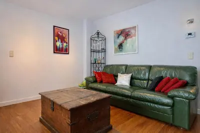 a living room with a green leather couch and a coffee table at Alhambra hideaway prime location in Brussels